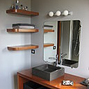 Une série d'étagère en merisier ont été installées pour compléter le rangement. Mitigeurs des vasques Totem de chez Lapeyre