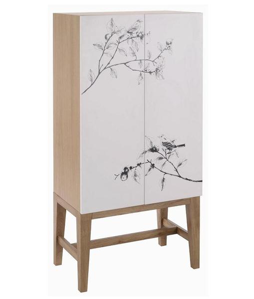 Quelques branchages japonisants ornent les portes du cabinet Brixham. Panneau de particules plaqué chêne. 70 x 140 x 40 cm. 400 €.