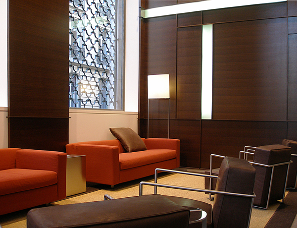 Hall d’entrée siège social Paris. L’espace d’attente du hall d’entrée du siège social d’une compagnie d’assurances situé près des Champs Elysées. Lambris en wengé réalisé avec des réservations lumineuses, mobilier en cuir et inox.