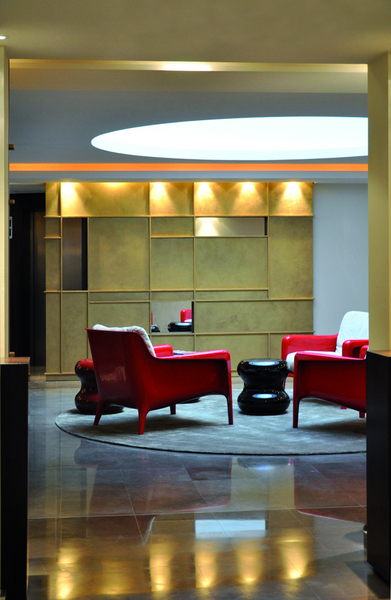 Lobby de l’hôtel Beauchamps. Panneaux muraux en patine or de Pierre Bonnefille, reprenant un graphisme inspiré des tableaux de Piet Mondrian. Fauteuil italien en laque rouge.