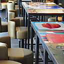 Restaurant Velvet. Gros plan sur les tables à hauteur de comptoir bar, les plateaux des tables ont été réalisés sur mesure en stratifié avec inclusion d’une photo illustrant le thème de l’univers d’un artiste fil conducteur de la décoration de l’hôtel. Les tabourets de bar ont été dessinés spécialement pour le projet. Restaurant Velvet. Gros plan sur les tables à hauteur de comptoir bar, les plateaux des tables ont été réalisés sur mesure en stratifié avec inclusion d’une photo illustrant le thème de l’univers d’un artiste fil conducteur de la décoration de l’hôtel. Les tabourets de bar ont été dessinés spécialement pour le projet.