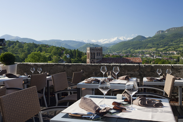 La terrasse offre une vue sur la bourgade et les massifs des Pyrénées