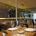 Beau bar en albâtre à l’entrée, tables en bois de sycomore, orchidées, collection de belles carafes en cristal de Baccarat.