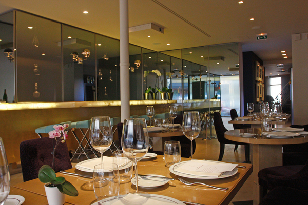 Beau bar en albâtre à l’entrée, tables en bois de sycomore, orchidées, collection de belles carafes en cristal de Baccarat.