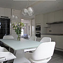 Parée de blanc, la grande cuisine devient pièce à vivre et s'ouvre vers les autres espaces de vie de l'appartement