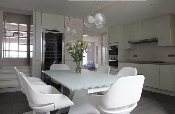 Parée de blanc, la grande cuisine devient pièce à vivre et s'ouvre vers les autres espaces de vie de l'appartement