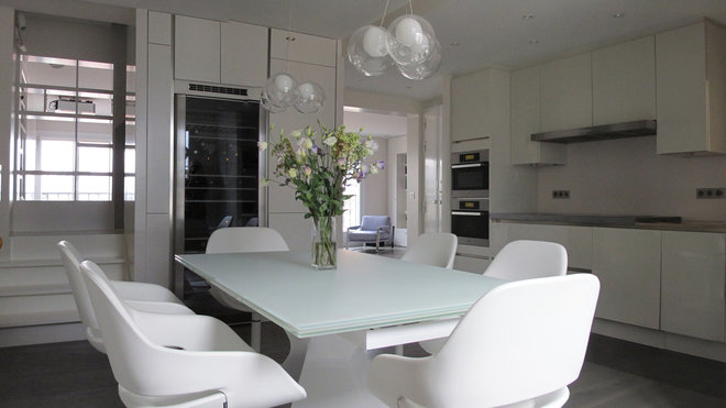 Parée de blanc, la grande cuisine devient pièce à vivre et s'ouvre vers les autres espaces de vie de l'appartement