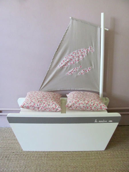 Pour ranger, ou jouer au navigateur. Coffre livré avec 2 coussins en textile fleuri type Liberty. Mat et voile amovibles. L 80 x 35 x 30 cm ou 100 cm avec le mat. 315 €. Banc coffre Côté Guinguette. www.gingerlily.fr