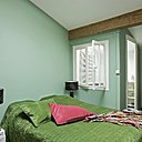 Une chambre déclinée dans les tons de vert. Dessus de lit, coussins et châle, Caravane, lampes, Alinéa, miroir, WR Woestijnroos, peinture, La Seigneurie.