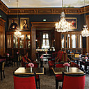 Boiseries, lustres de cristal et ancêtres pendus sur les murs de la splendide salle du restaurant