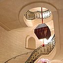 L'escalier monumental bordé par sa fière rampe en fer forgé rehaussé d'or