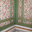 Deux largeurs de galons émeraude superposés s’entrecroisent pour structurer les murs d’une des chambres du château de Fontaine-Française recouverts de tapisseries à l’indienne. La géométrie des bandes de galons contraste avec les courbes délicates des fleurs et répond à l’inclination luxueuse du lieu.