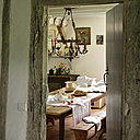 Un salon très cosy vient s’ouvrir sur la cuisine. Linge de table, vaisselle et table de ferme de famille,  ancien fourneau à bois transformé en meuble, au-dessus, nature morte, Léonce Fort.
