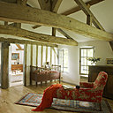 Le premier étage dessert deux chambres et une grande pièce faisant office de dortoir quand la maison est remplie. Méridienne de famille et lit de bébé  recouverts d’une toile de Jouy, Toto Solde, fauteuil basque, buffet de cuisine, plaid, Ikéa.