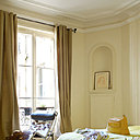 Dans cette chambre inondée de soleil, sur un tapis AMPM,  une superbe reproduction de la chaise longue « poney » signée Le Corbusier , un dessus de lit aux tons du Midi , couleur anis, Caravane, tringle, Leroy Merlin, rideaux et tapis , AMPM. Le couloir de l’entrée donnant sur la salle à manger, affiche une certaine sobriété, console AMPM, miroir The Conran Shop, peinture, Guérin, applique, Habitat.