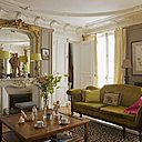 Une atmosphère paisible rendue par des couleurs chatoyantes et un classicisme revisité. Autour d’une table basse, Mise en demeure, canapé chiné, fauteuils recouverts de tissus Designer Guild, tasses , Marie Dâage, statue représentant le général de Boisdeffre, lampes, Artheme Galerie, rideaux, Marché  Saint-Pierre, tapis, Casa Lopez.