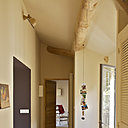 Une entrée couleur amande en accord  avec les tommettes, dessert le salon et la chambre des parents à droite. Tapis en tommettes de récupération inséré dans un enduit béton ciré, Mercadier, applique, Jielde, Maison montigny, suspension photos « Céline Wright », Maison Montigny.