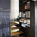 Un escalier aménagé en bibliothèque réalisé par Serge Van Doesburg, dessiné par Caroline Costedoat architecte, lettres, Atelier 154, peinture noire de tableau, Leroy Merlin.