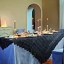 Les nouvelles tendances 2012 : une nappe de table en crochet teintée couleur ardoise recouvrant une nappe de lin gris galet assortie aux housses de chaise de la même couleur.