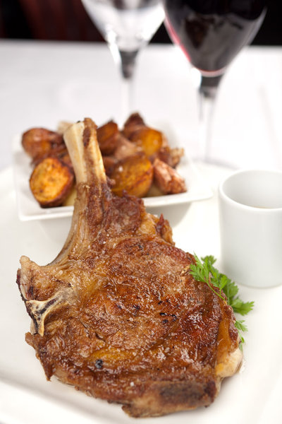 Belle côte de veau épaisse servie avec les incontournables pommes de terres sautées