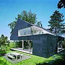 A Seeheim, en Allemagne, la maison individuelle en bardage de cuivre gris foncé se dresse comme un monolithe flanqué d’ouvertures