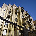 L’agence Make a rénové un bloc de bâtiments de six étages datant des années 60, relativement peu attrayant du centre de Londres, en le revêtant intégralement de laiton doré et de balcons à console en cuivre perforé