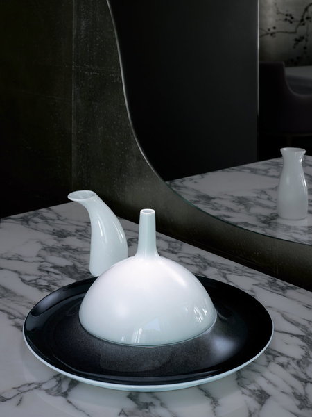 La cloche de porcelaine bombée posée sur l'assiette et la petite saucière laisse présager un met délicat concocté par Anne-Sophie Pic