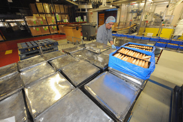 Les boîtes de fer blanc se remplissent des biscuits juste sortis des chaînes avant d'être rassemblés dans les boîtes d'assortiments