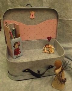 Une partie de la valise plus large comporte une pochette et peut être divisée par un casier où l'on peut ranger ses crayons et crochets