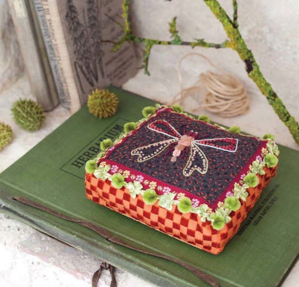 Coussin Libellule, doux mélange de matières et de tissus, rehaussé par la broderie et les galons.