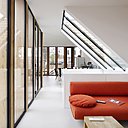 Au sommet, perché sur les toits de Paris, une grande pièce de vie et un salon en pleine lumière.