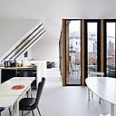 Au dernier niveau, cuisine et salle à manger pour tous, terrasse et lumière à foison grâce aux hautes baies vitrées et fenêtres de toit.