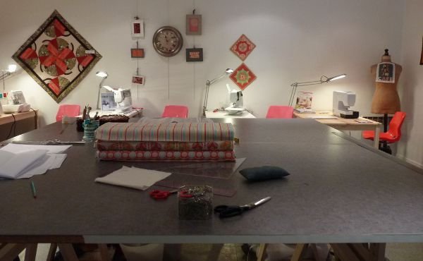 L'espace couture, vaste atelier avec table de coupe et postes pour les machines à coudre