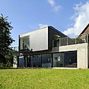 La maison s'intègre parfaitement au terrain en pente douce.