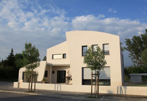 La façade sud du Bateau Ivre, sur voie, capte la lumière grâce à ses nombreuses ouvertures et fait ainsi circuler le soleil dans toute la maison et le jardin