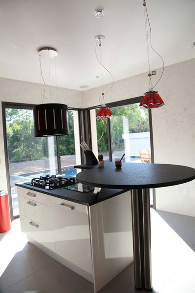 Mettant en valeur la vue sur le jardin et La Sorgue, Les grandes baies vitrées de la cuisine et du séjour prolongent le regard et la bâtisse se fond dans le paysage.