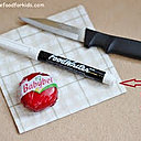 Un Mini Bel, un couteau de cuisine, une serviette en papier et un feutre alimentaire.