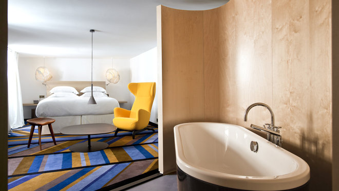 Ouverte sur la chambre, la salle de bains lambrissée de bois clair