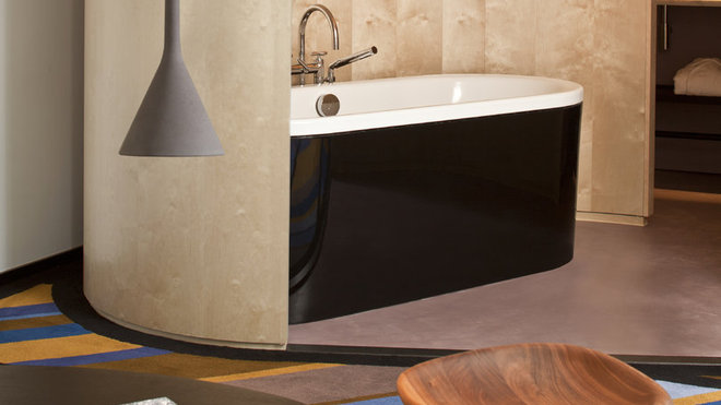 Une élégante alcôve ouverte sur la chambre, pour accueillir la baignoire dans les suites