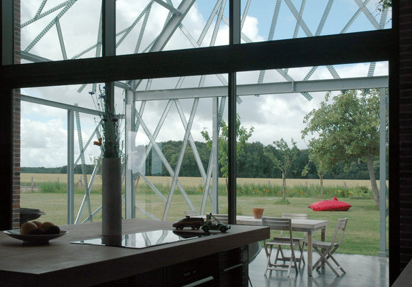 La cuisine s’ouvre sur l’extension du mur pignon, la lumière, la nature et la campagne.
