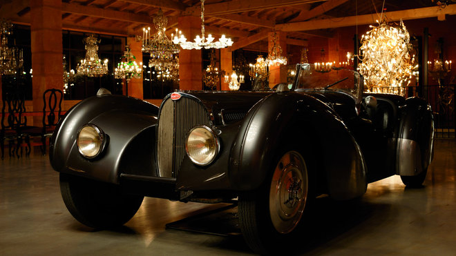 L'exposition de nuit met en miroir les deux merveilles, lustres et automobiles d'exception.