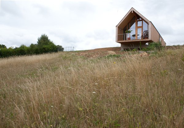Le bâtiment, situé dans un lotissement, offre une grande ouverture du mur pignon.