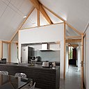 Une cuisine adossée à l’espace salon, avec une communication de part et d’autre de la grande pièce à vivre.