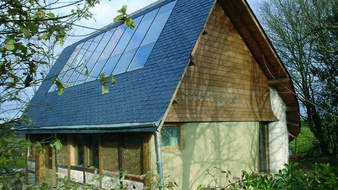 La maison est entourée de haies d'arbres à feuilles caduques qui forment un ombrage bénéfique en été et qui laisse filtrer la lumière solaire en hiver.