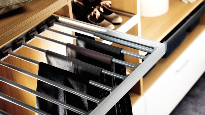 Le confort d’utilisation dépend notamment des astuces de rangement. Parmi ces astuces, le porte-pantalons coulissant. Pérène. www.perene.com