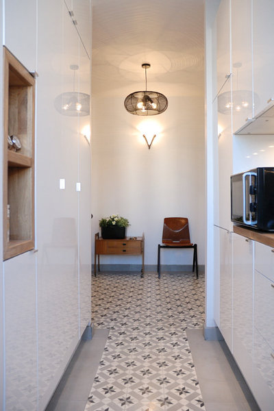 La cuisine compacte, désormais ouverte, est habillée avec un double linéaire de rangement intégrant deux plans ce travail.