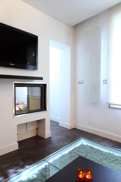 Entre la chambre et l’espace séjour, la partie du mur porteur conservé intègre des réservations techniques pour la TV et la musique diffusée dans tous les espaces.