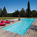 Bassin en "L" élégamment posé au milieu d'un paysage rappelant la Toscane.