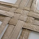 Les bandes de papier se croisent et s'assemblent pour faire le fond de la panière.