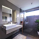 La salle de bains est nappée de grandes dalles de grès cérame émaillée avec surface à effet tissée.